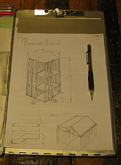 A rough sketch of a free standing rotating bookcase, on top is an angled reading surface hinged to contain a secret compartment